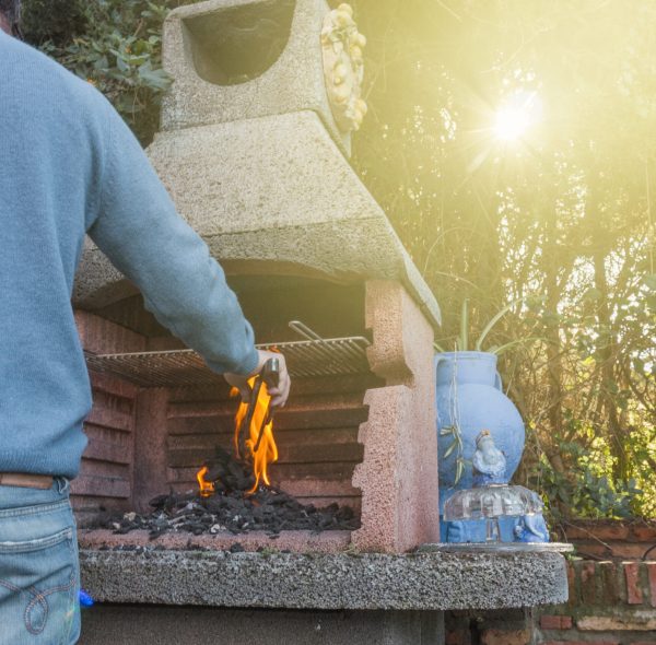rear-view-man-burning-coal-barbecue